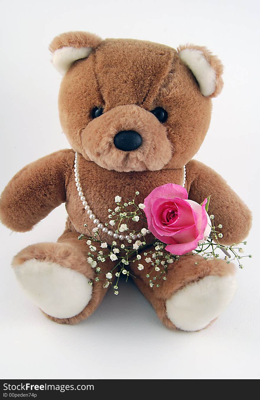 Cute teddy bear holding a rose and wearing a strand of pearls. Cute teddy bear holding a rose and wearing a strand of pearls.