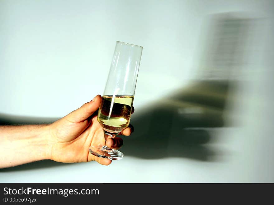 Hand of a man holding a glass of white wine drinking to. on white background, shadow reflected. Italy. Hand of a man holding a glass of white wine drinking to. on white background, shadow reflected. Italy