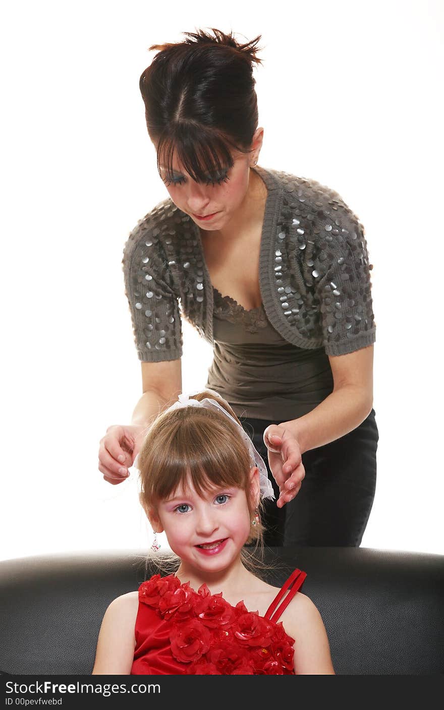 Hairdresser Mom gives a last minute adjustment to the bow in her daughter's hair, before her photo shoot begins. Hairdresser Mom gives a last minute adjustment to the bow in her daughter's hair, before her photo shoot begins.