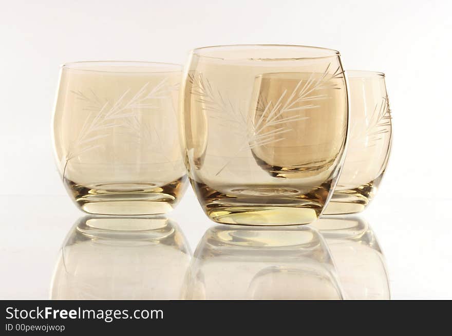 A glass beside a stack of white plates - on white background. A glass beside a stack of white plates - on white background