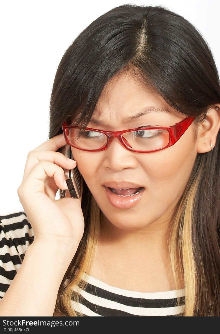 A woman wearing red eyeglasses talking on the phone. A woman wearing red eyeglasses talking on the phone