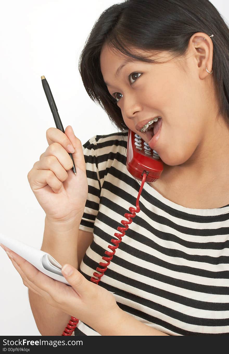 A woman with a notepad making a call on the phone. A woman with a notepad making a call on the phone