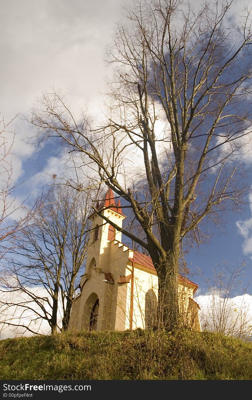 Historical roman-catholic church at the top of the hill with the trees on the sides