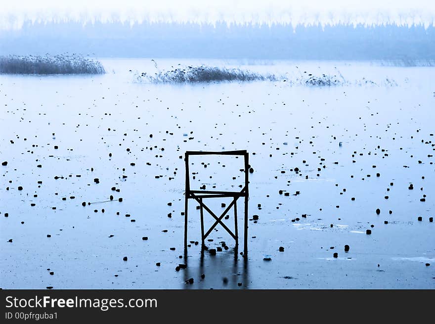 A chair on frozen misty lake. A chair on frozen misty lake