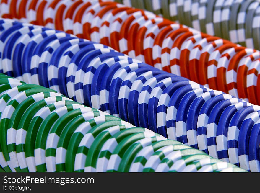 Abstract background with casino chips in five colors: red, blue, green, gray and white