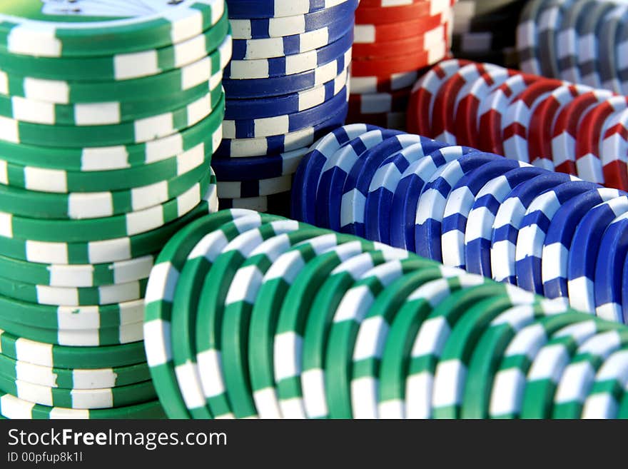 Abstract background with casino chips in five colors: red, blue, green, gray and white