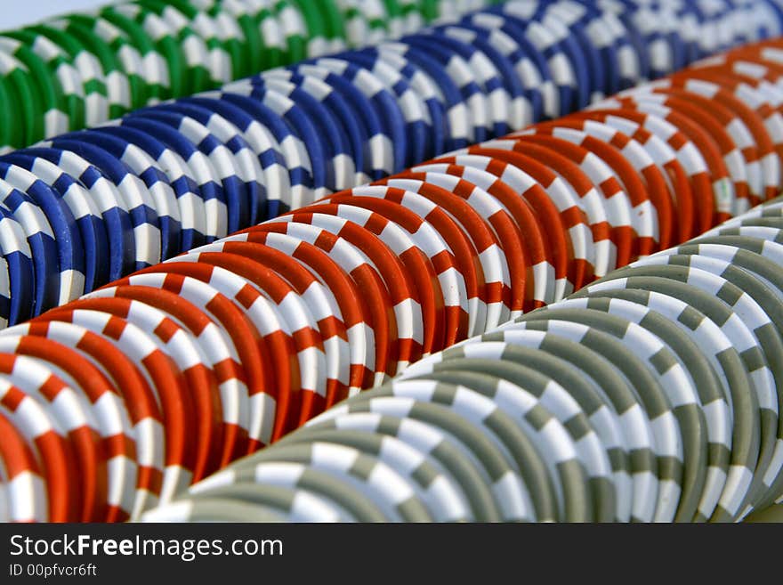 Abstract background with casino chips in five colors: red, blue, green, gray and white