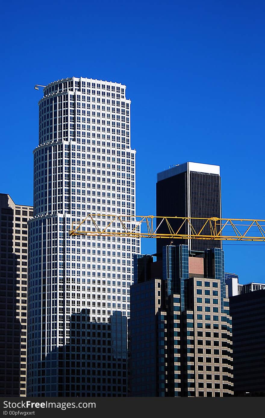 A construction crane is busy at work on a beautiful clear sunny day in downtown Los Angeles, California. A construction crane is busy at work on a beautiful clear sunny day in downtown Los Angeles, California.