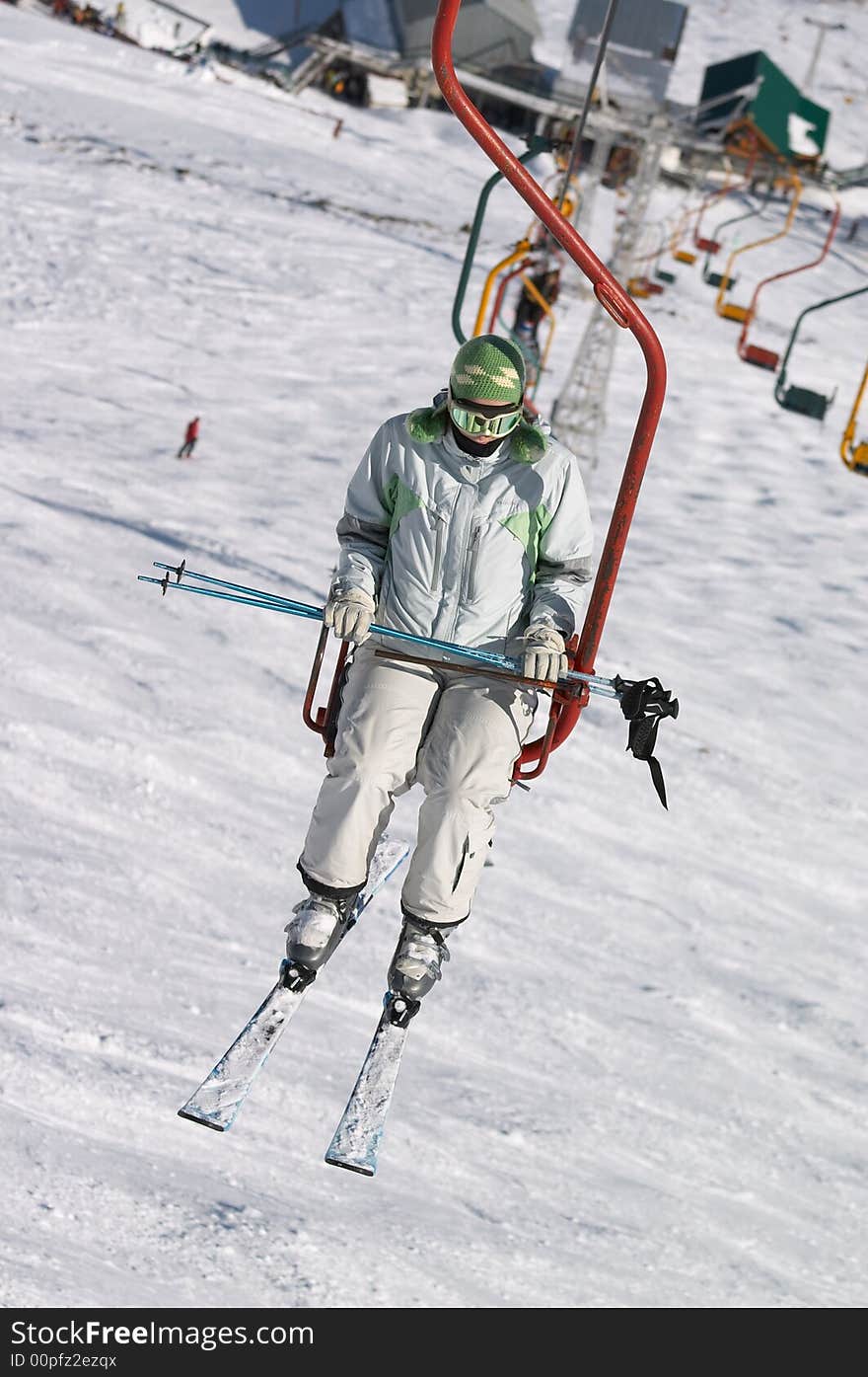 Skier on chair lift in mountain resort