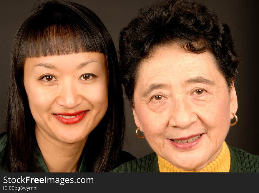 Mother and daughter smiling at the camera.