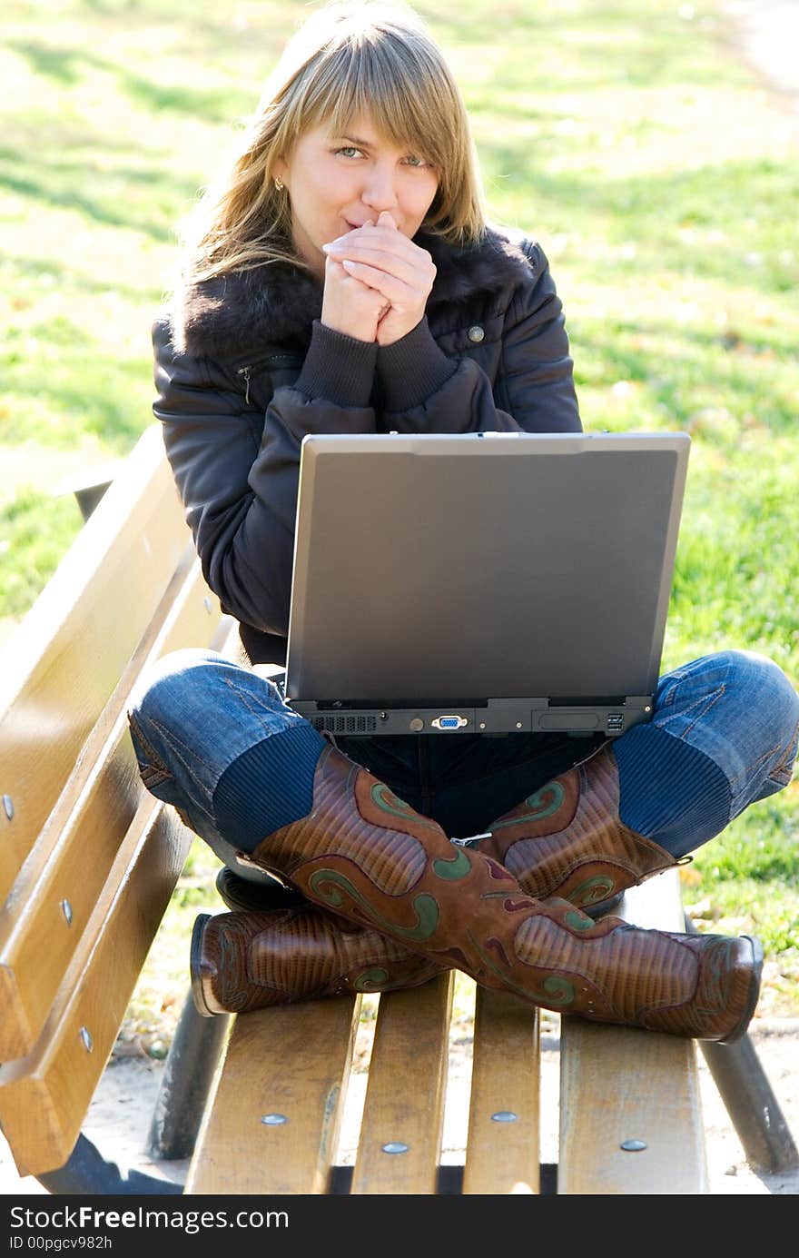 Young woman with laptop at the autumn park. Young woman with laptop at the autumn park