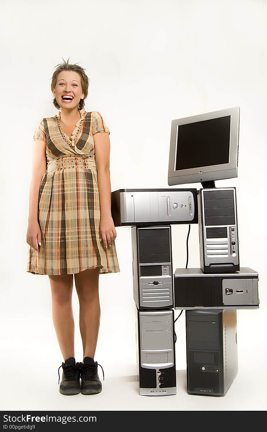 Beautiful young girl standing next to bunch of computers. Beautiful young girl standing next to bunch of computers