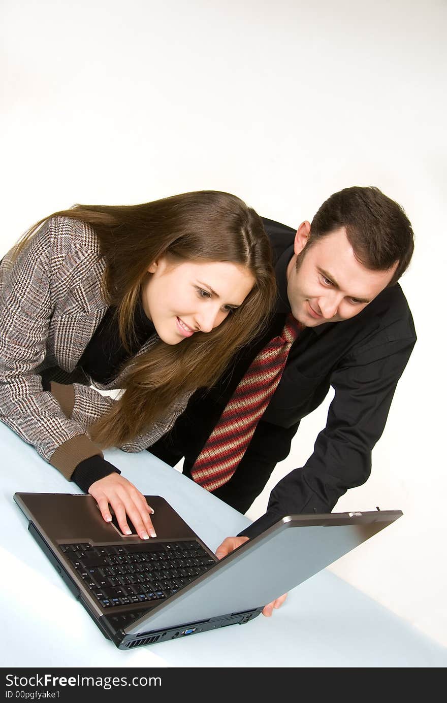 Pair of managers communicating, working on laptop computer. Pair of managers communicating, working on laptop computer