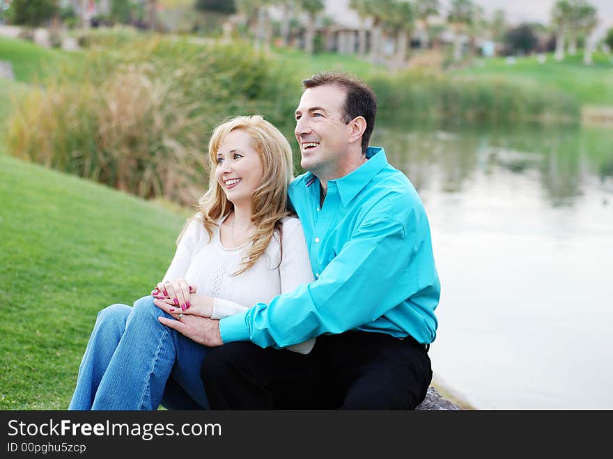 A happy couple smiling in green park environment