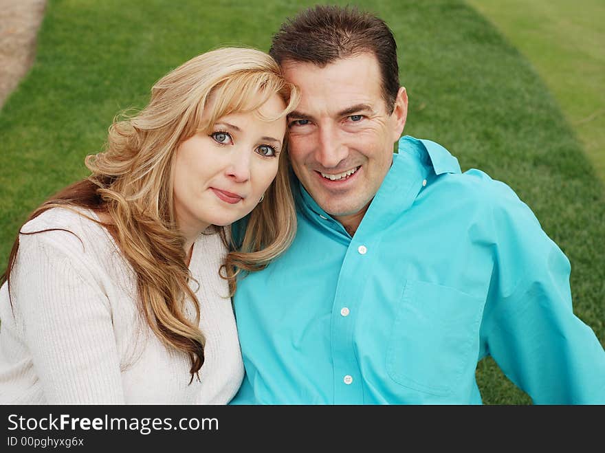 Happy couple is smiling in green park environment