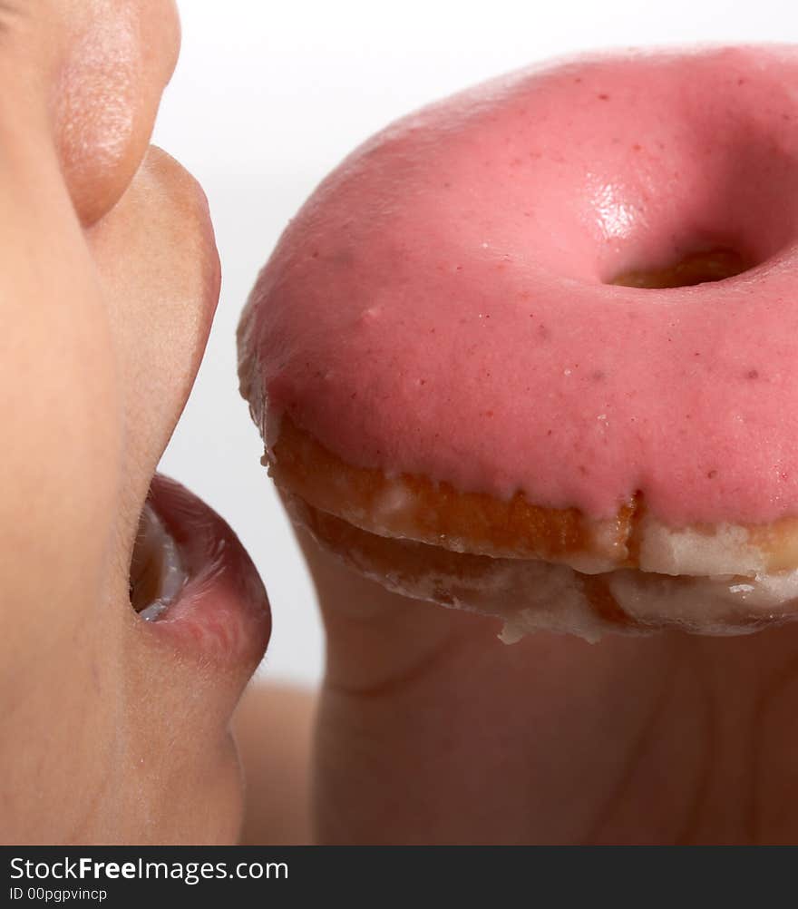 Taking a bite out of a doughnut over a white background