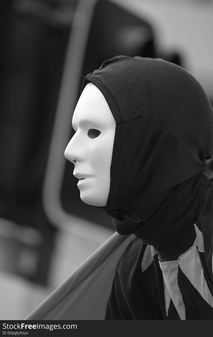 A performing artist up close wearing a mask in black and white. A performing artist up close wearing a mask in black and white