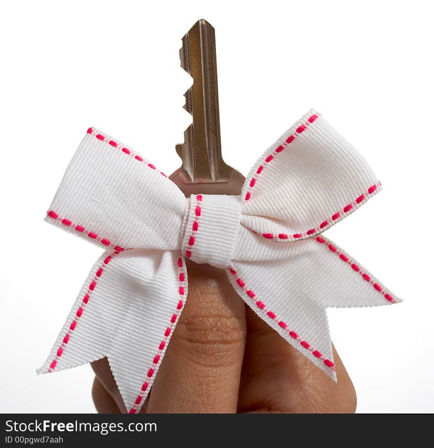 A hand with a ribbon holding a key