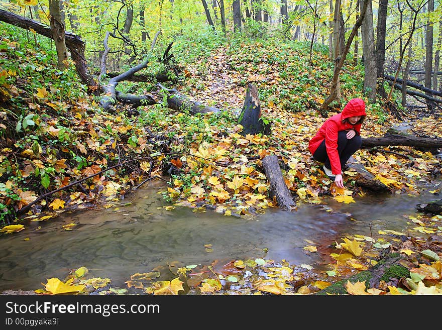 Autumn and lonely girl in red raincoat