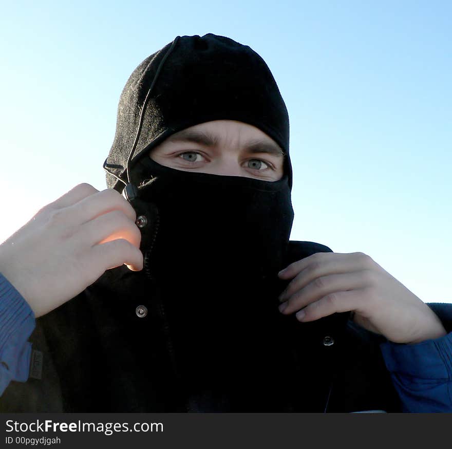 The young man in the winter sports cap closing the face. The young man in the winter sports cap closing the face