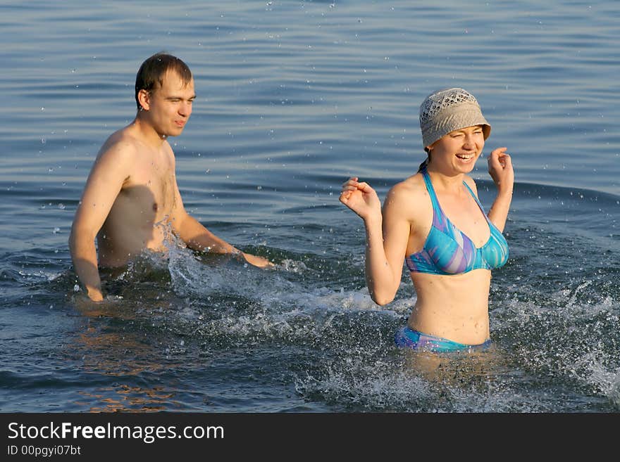 The boy and the girl play in water. The boy and the girl play in water