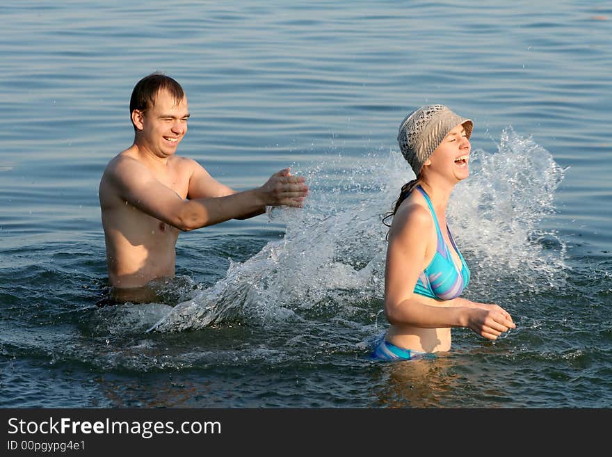 The boy and the girl play in water. The boy and the girl play in water