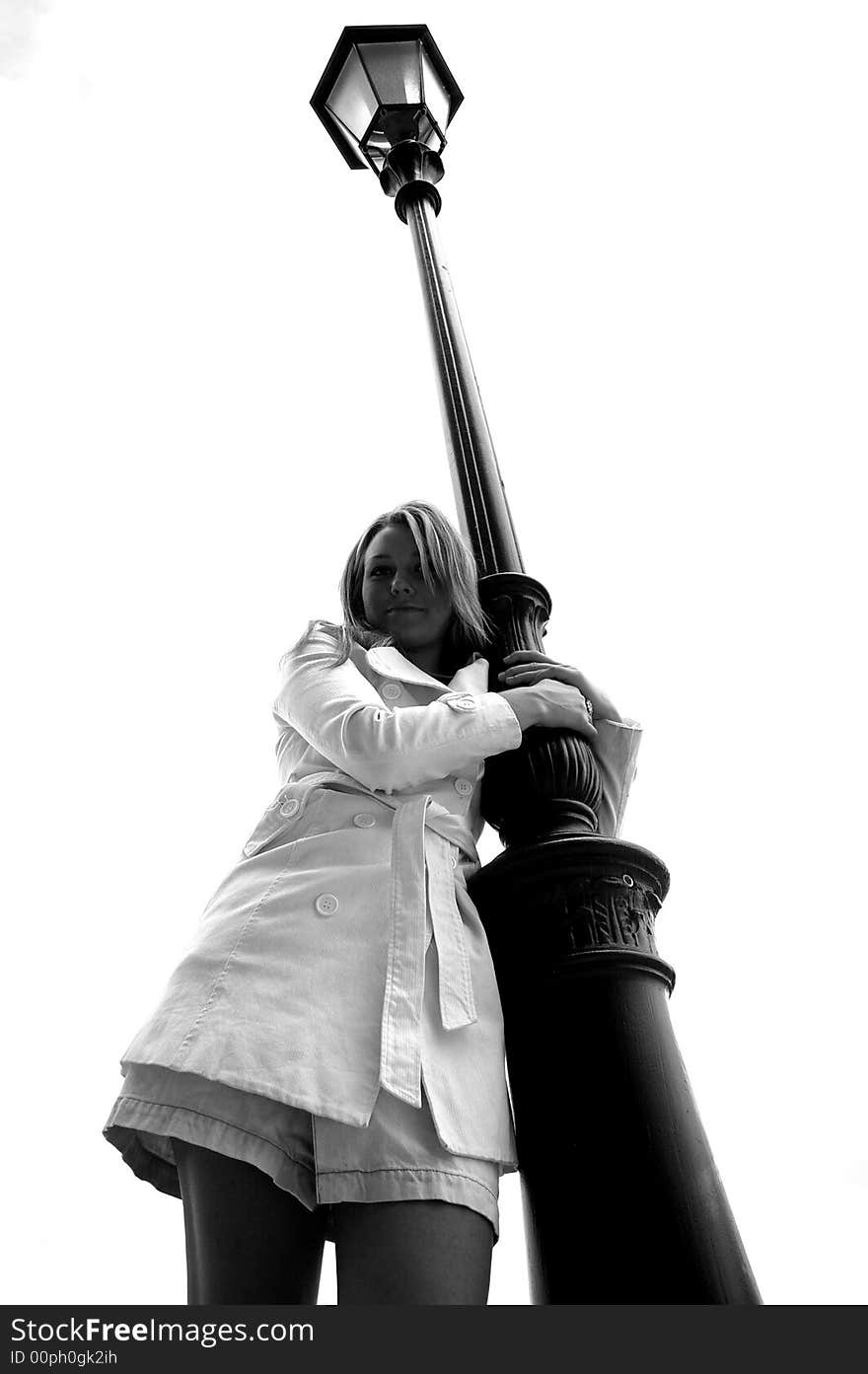 Beautiful girl standing by a light pole. Beautiful girl standing by a light pole.