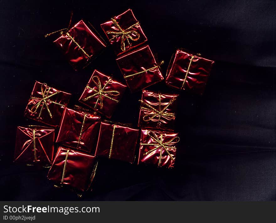 Dark image background of red foil present decorations. Dark image background of red foil present decorations