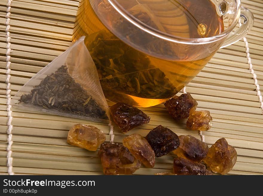 White tea, nylon tea-bag and golden sugar. White tea, nylon tea-bag and golden sugar