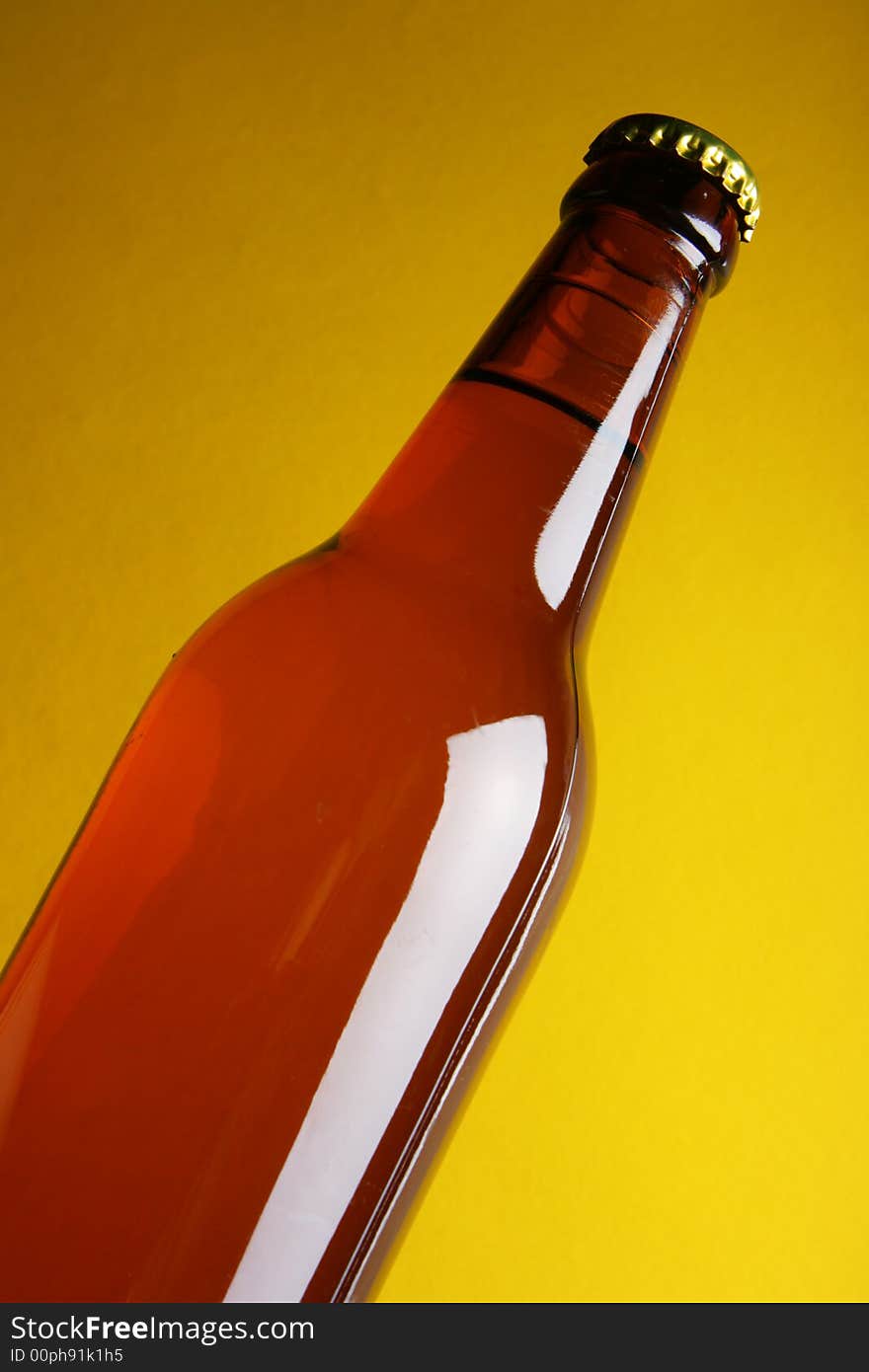 Beer bottle close-up over yellow background. Beer bottle close-up over yellow background