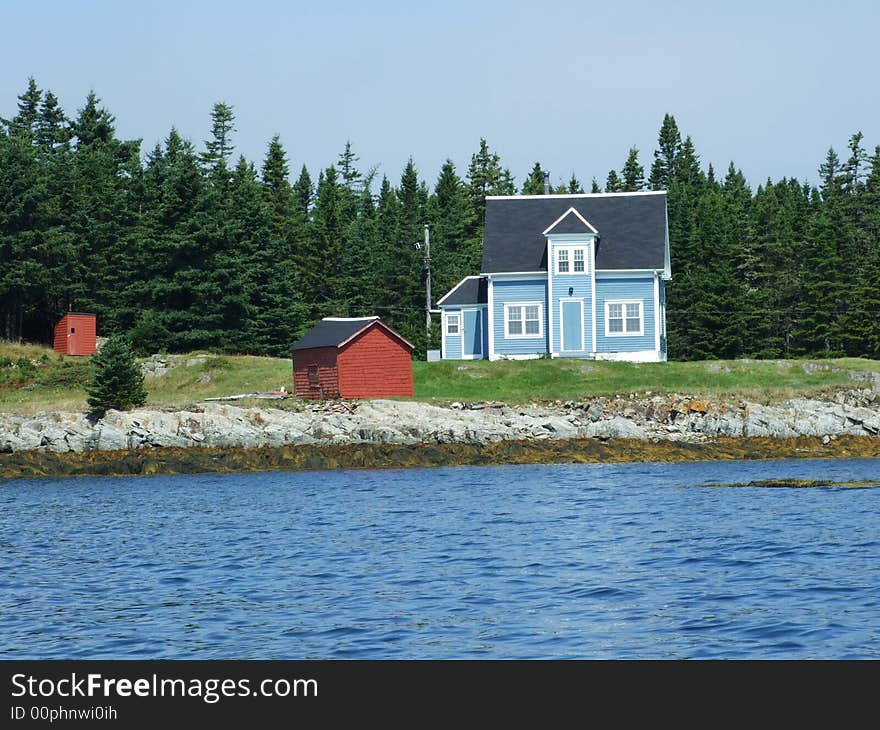 Blue house with white trim and a red shed on Outer Hirtle Island Lahave Lunenburg County Nova Scotia Canada. Blue house with white trim and a red shed on Outer Hirtle Island Lahave Lunenburg County Nova Scotia Canada