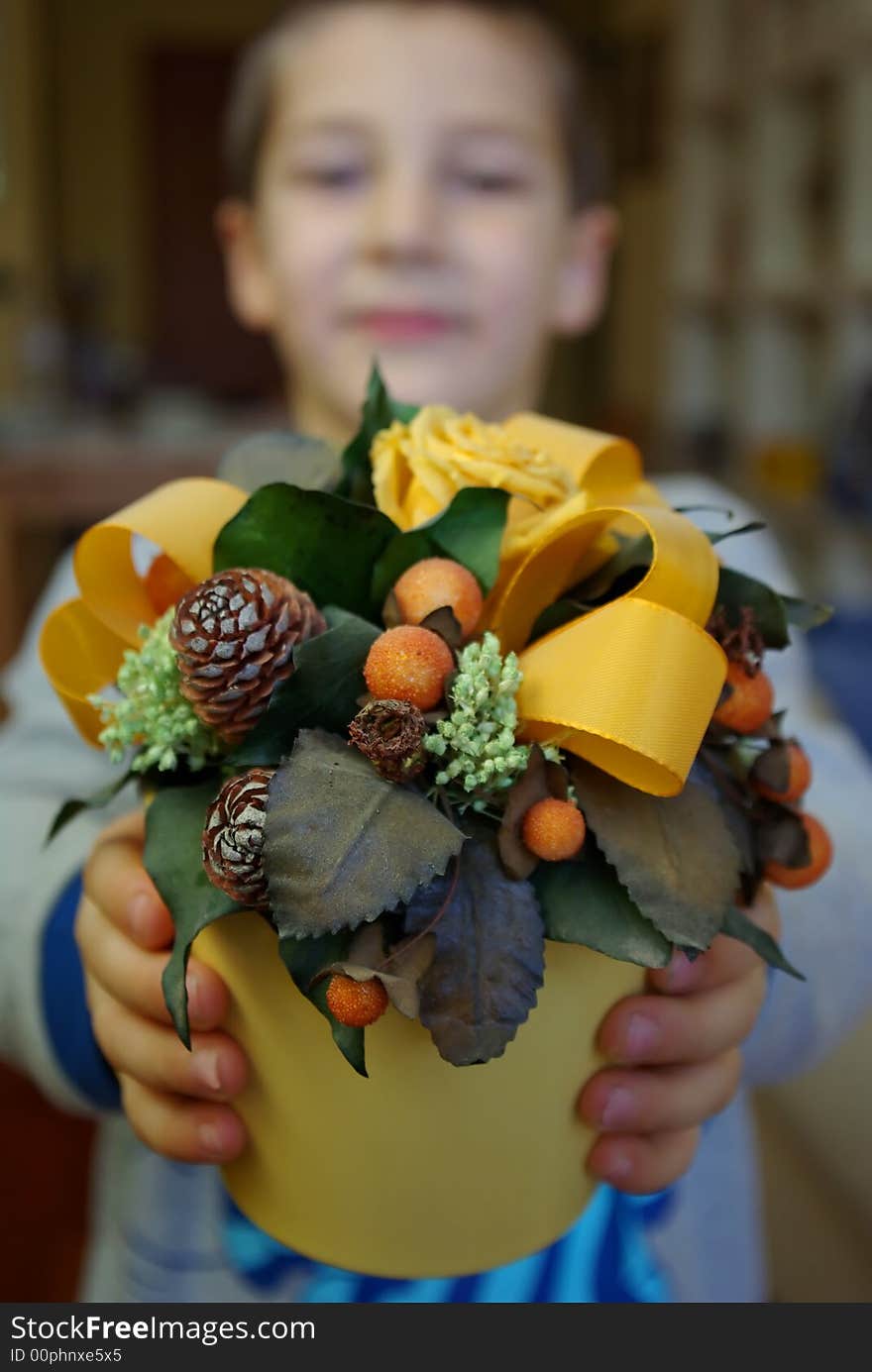 A child has a vase of dried flowers. A child has a vase of dried flowers