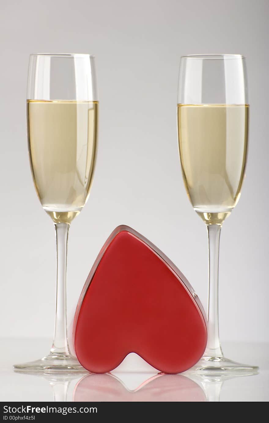 Two glasses of champagne with red heart in the middle. Two glasses of champagne with red heart in the middle