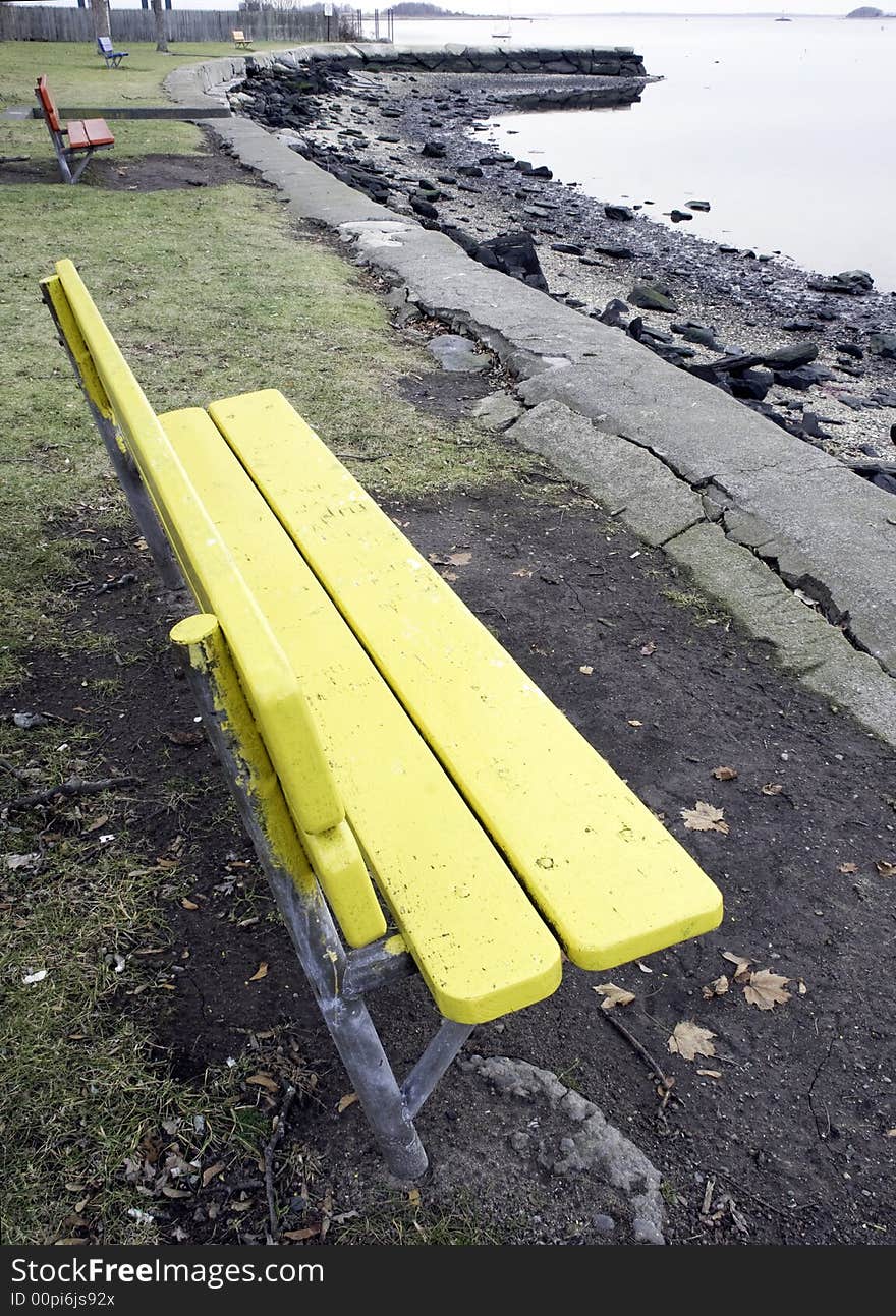 Colorful benches overlooking a river on a windless day. Colorful benches overlooking a river on a windless day