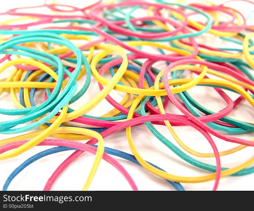 Close up of multi-colored rubber bands on white background