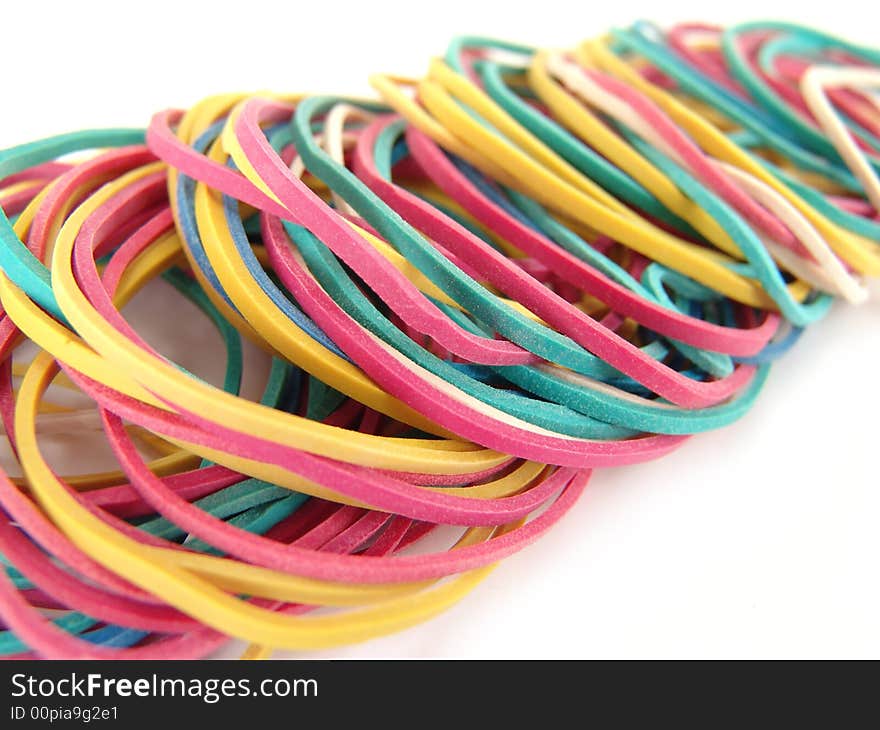 Close up of multi-colored rubber bands on white background