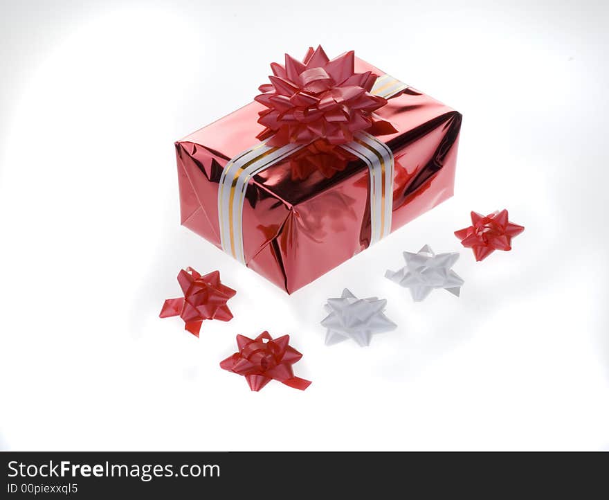 Red gift box with a white ribbon and paper flowers isolated on a white background. Red gift box with a white ribbon and paper flowers isolated on a white background.