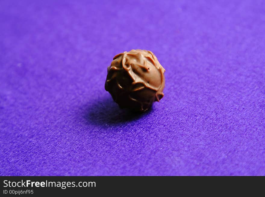 Fancy globe chocolate over a violet background with interesting lighting and shadow. Fancy globe chocolate over a violet background with interesting lighting and shadow.