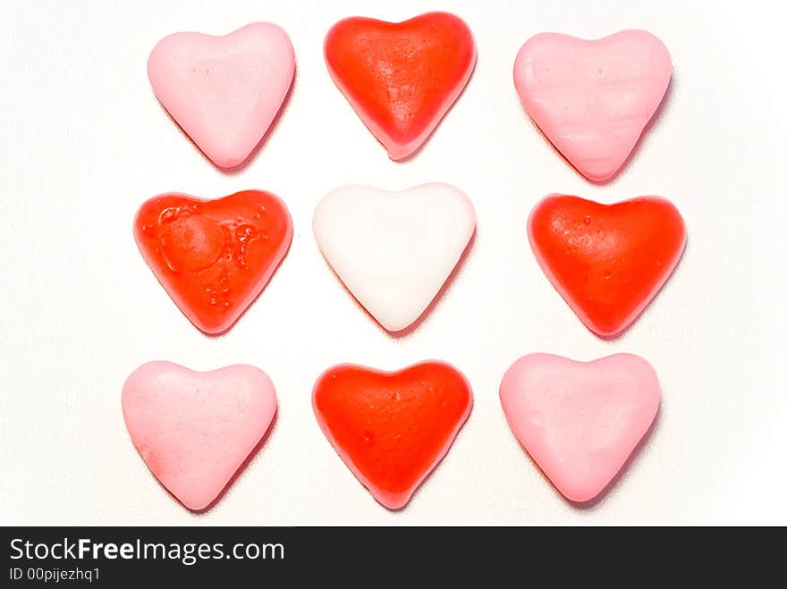 Close up red and pink candy hearts in square isolated on white