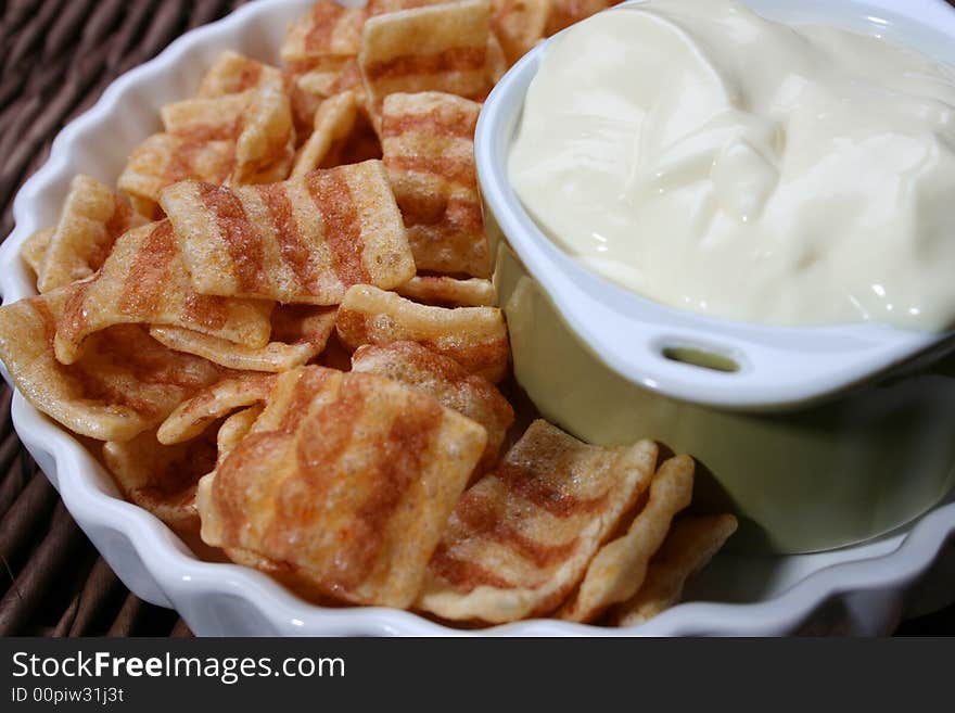 Chips in a white bowl with dip in a green bowl. Chips in a white bowl with dip in a green bowl