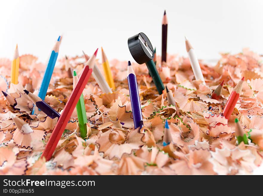 Colored pencils and pencil sharpener in white background