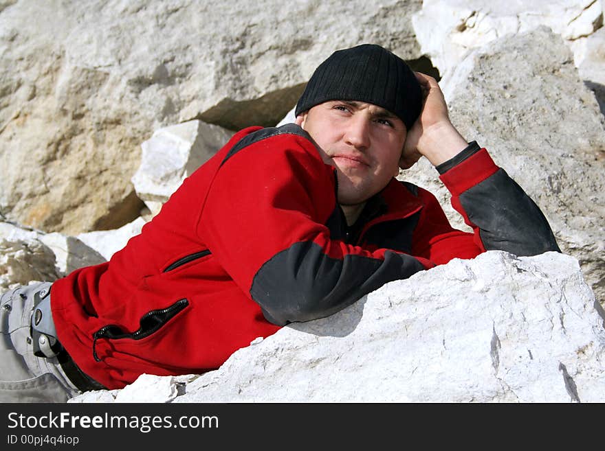 Thinking man in red blouse and black hat in a limestone quarry