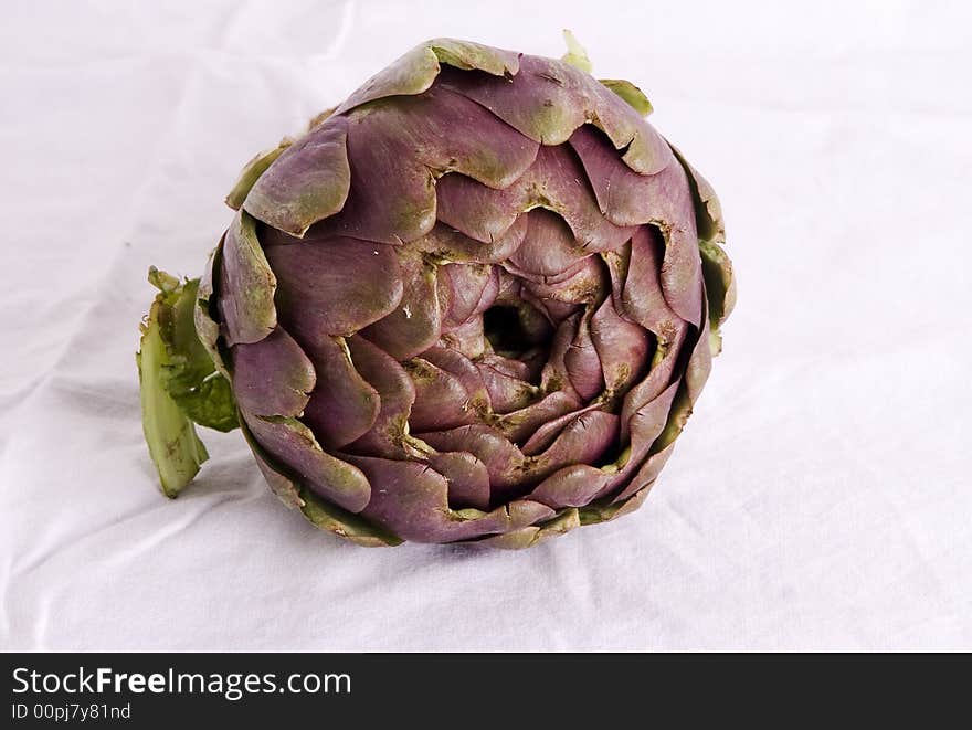 Close shot of a purple artichoke, also known as carciofo in Italy. Isolated on a white background.