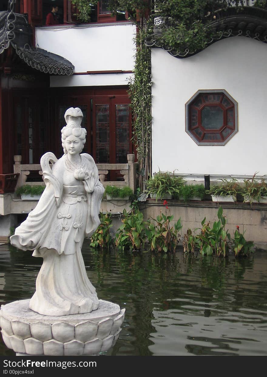 This image depicts a statue of a female in a Chinese garden. This image depicts a statue of a female in a Chinese garden.