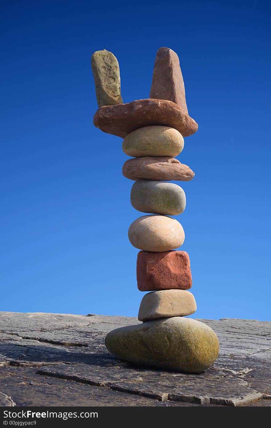 Column of balanced boulders against blue sky. Column of balanced boulders against blue sky