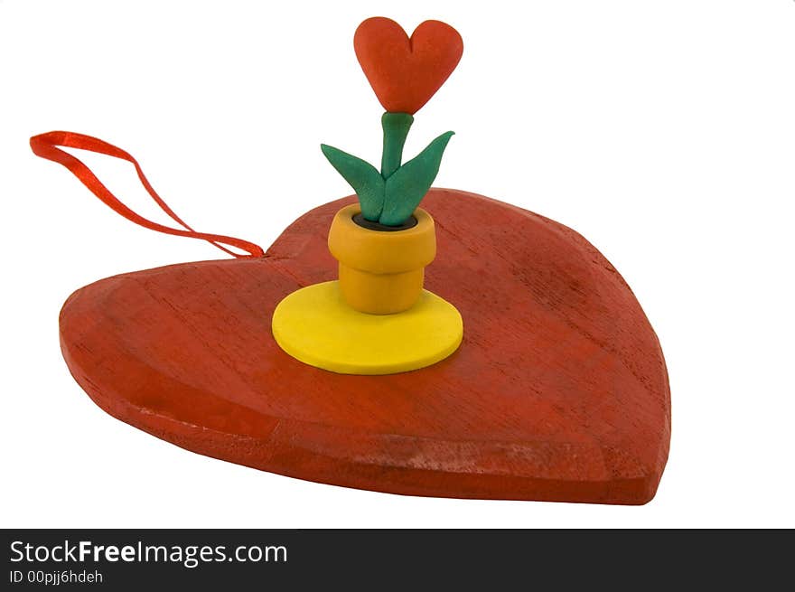 Red wooden heart with a pot of heart-shaped flower, isolated on white. Red wooden heart with a pot of heart-shaped flower, isolated on white.