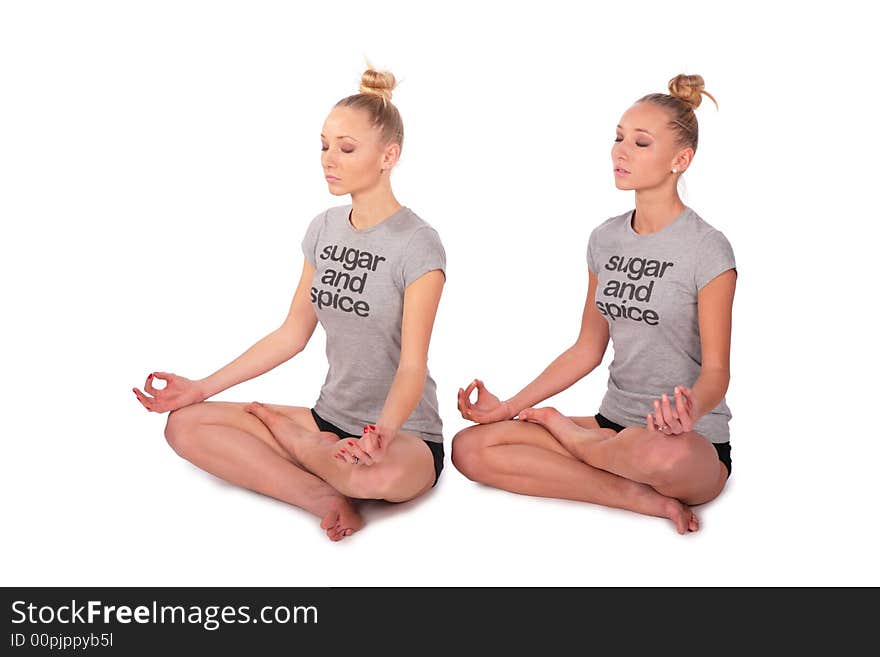 Twin sport girls meditating half-turned on white