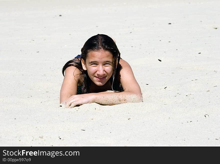 Girl lays on the sunny sand beach, warming up on hot sand after long swimming. Girl lays on the sunny sand beach, warming up on hot sand after long swimming