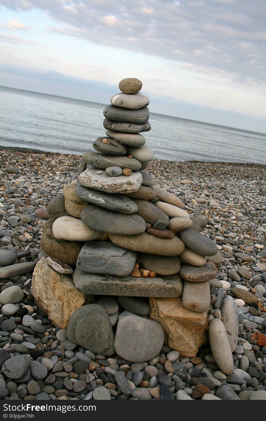 A tower made of sea rounded stones (pebbles) on the beach. A tower made of sea rounded stones (pebbles) on the beach