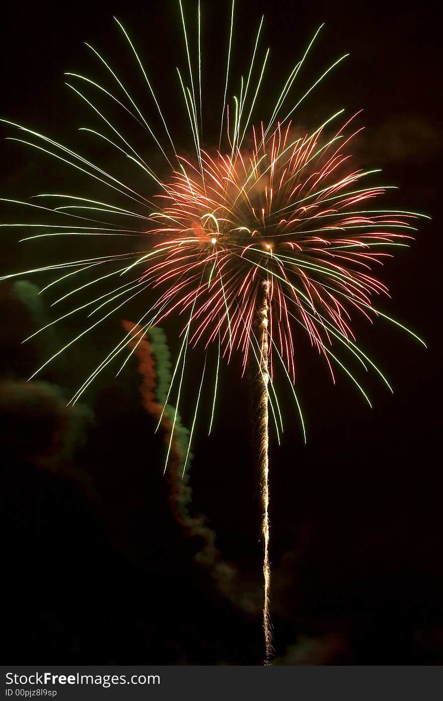 Firework blasts light up multicolored smoke trails. Firework blasts light up multicolored smoke trails